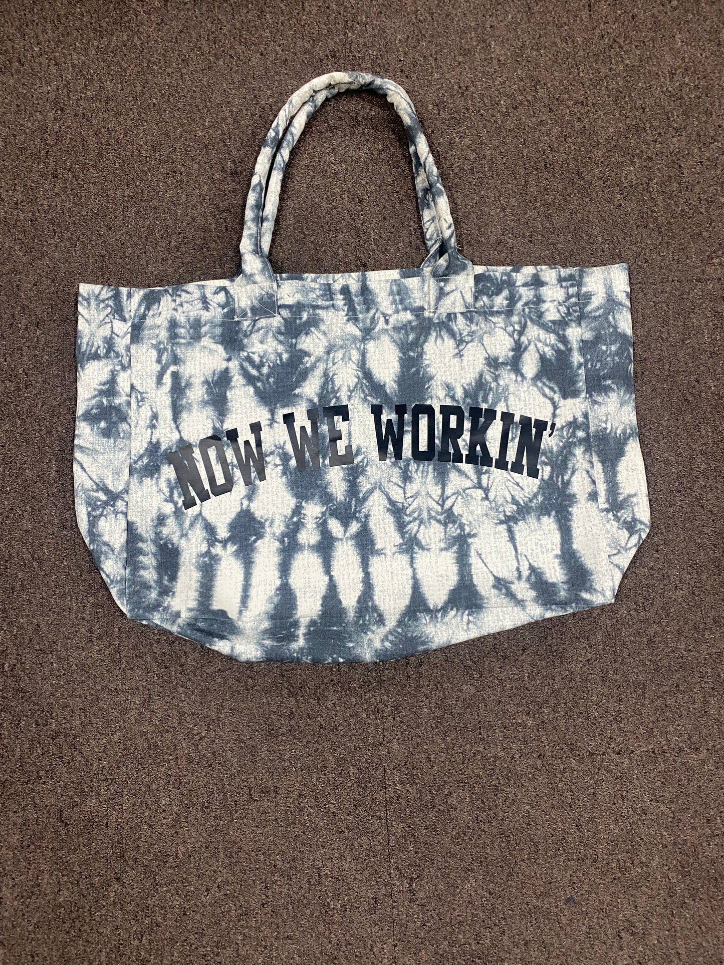 NOW WE WORKIN’ TIE-DYE TRANSIT TOTE